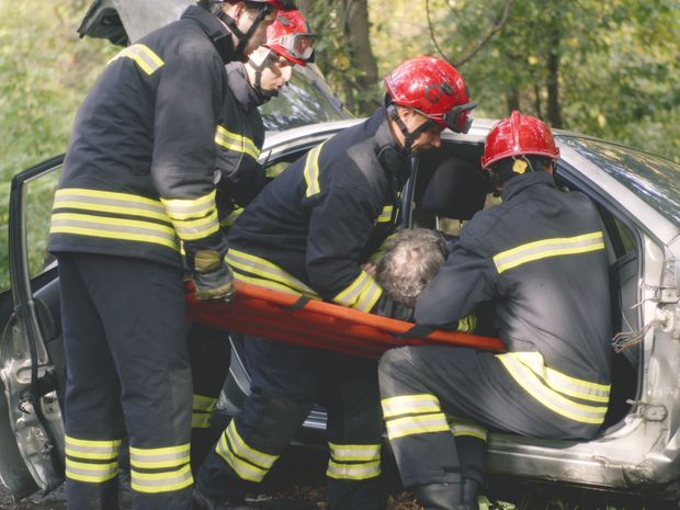 First responders extracting a driver from a wrecked vehicle